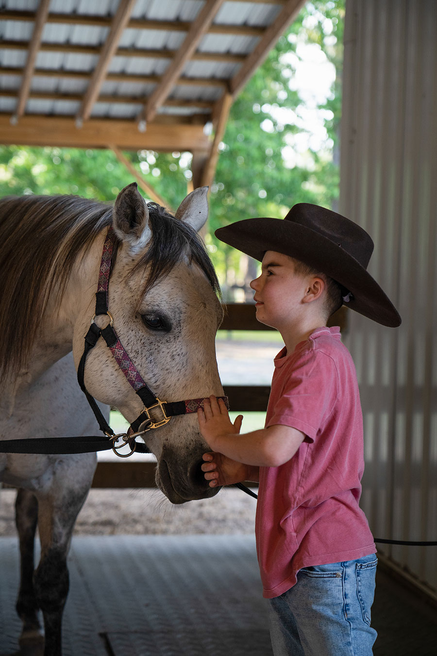 Photo of Leighton, a rider talking to RJ, a horse at Faith Equestrian Therapeutic Center